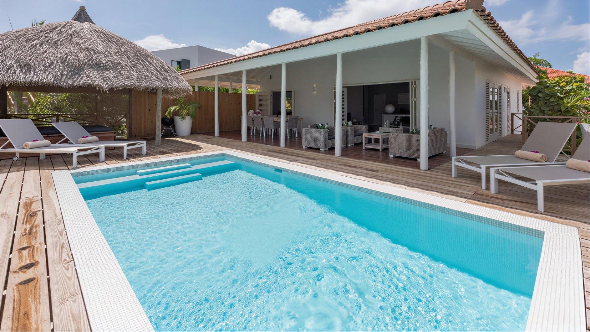 Zwembad met palapa en ligbedden, Villa Vidalou Curaçao